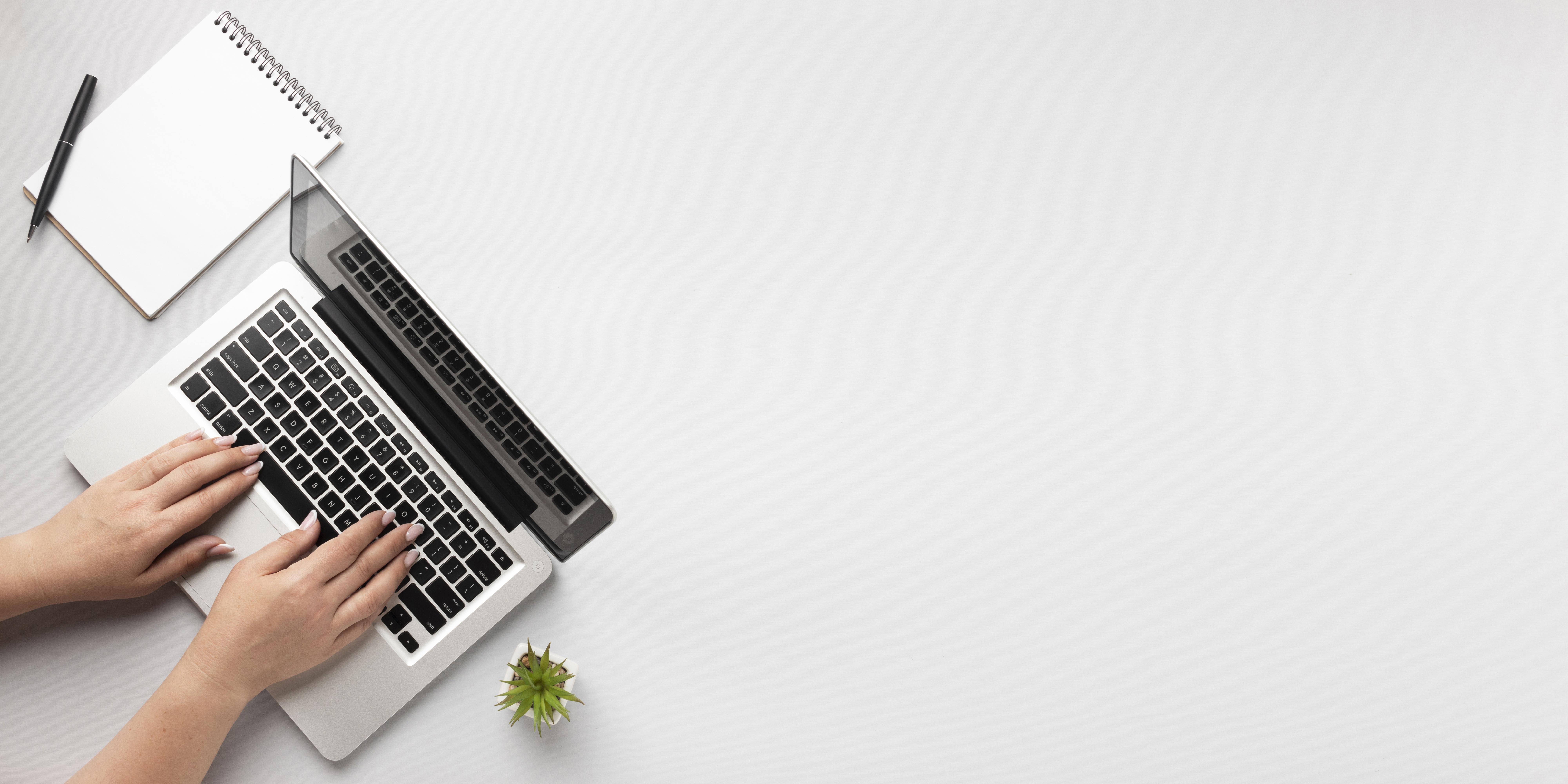 A lady's hands typing on a laptop. There is a paper and pen beside the laptop. Text reads publications.